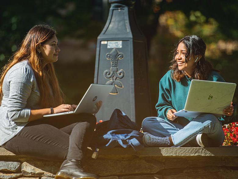 Two students interacting near the college's railroad clock